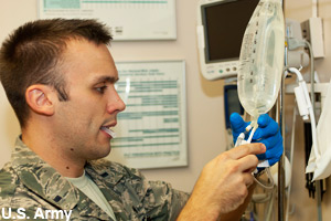 An army nurse giving a patient medicine
