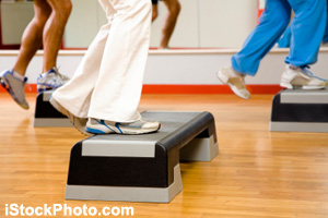A fitness trainer teaches step aerobics.